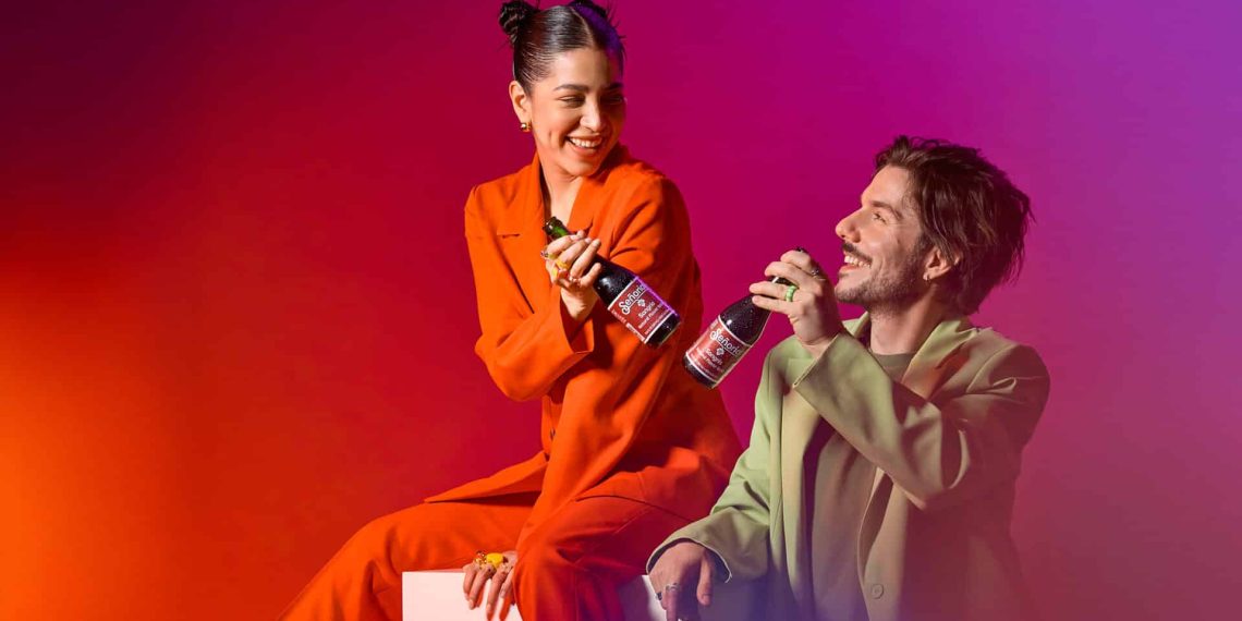 Two friends enjoying Sangria Senorial bottles, sharing a joyful, stylish moment that highlights a vibrant, premium non-alcoholic lifestyle.