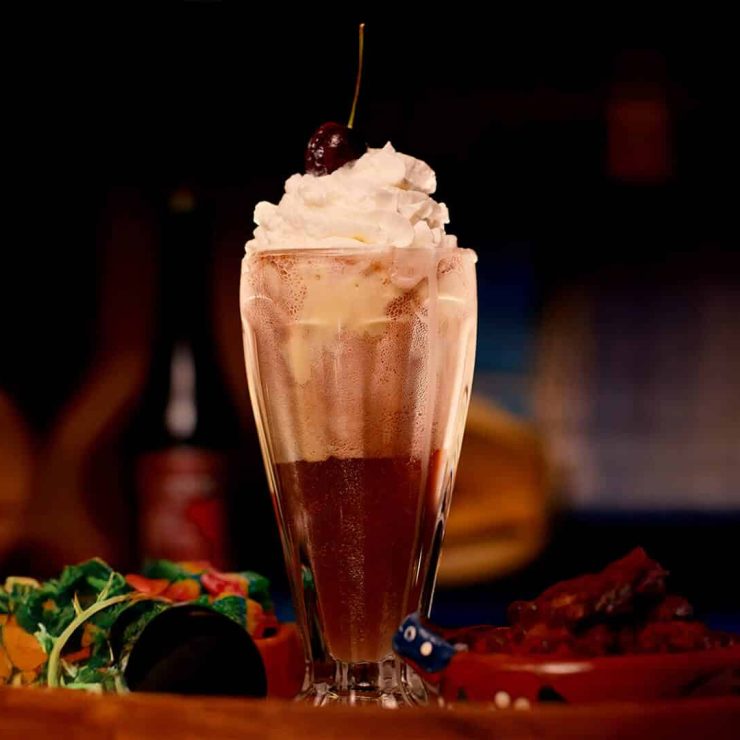 Creamy Sangria Senorial float topped with whipped cream and cherry, presented as a rich, indulgent non-alcoholic treat.
