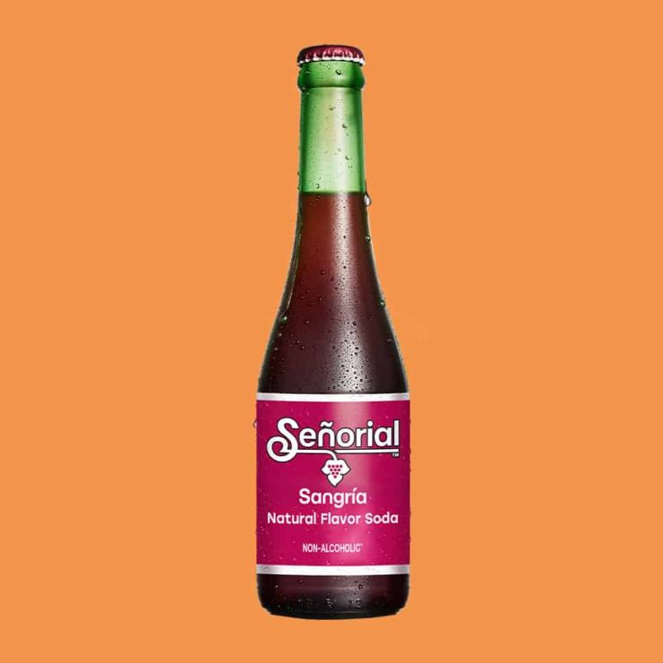 Sangria Senorial glass bottle with deep red soda, condensation details, and a vibrant label, presented as a refreshing premium non-alcoholic drink.