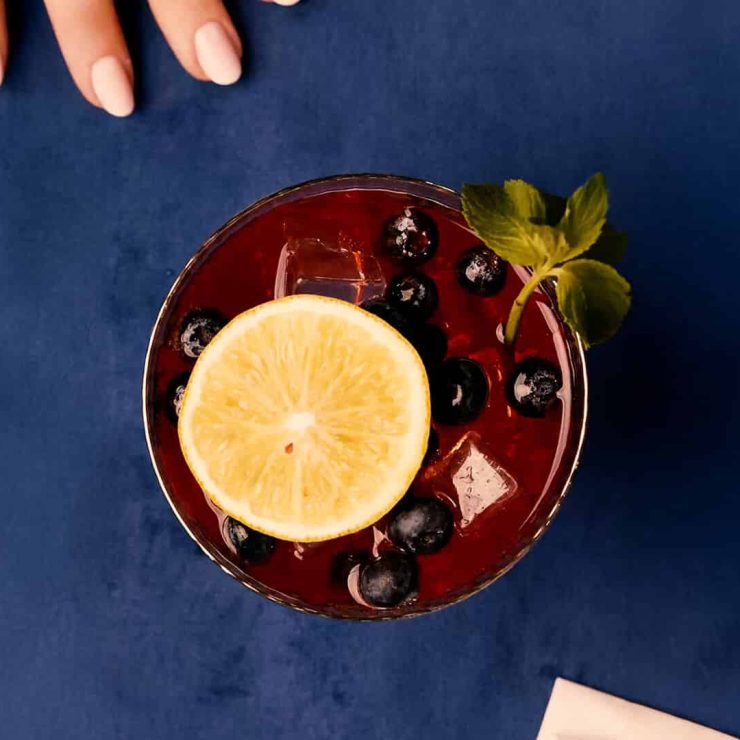 Top view of a Sangria Senorial mocktail with citrus slice, fresh berries, and mint, styled as a refined and refreshing non-alcoholic drink.