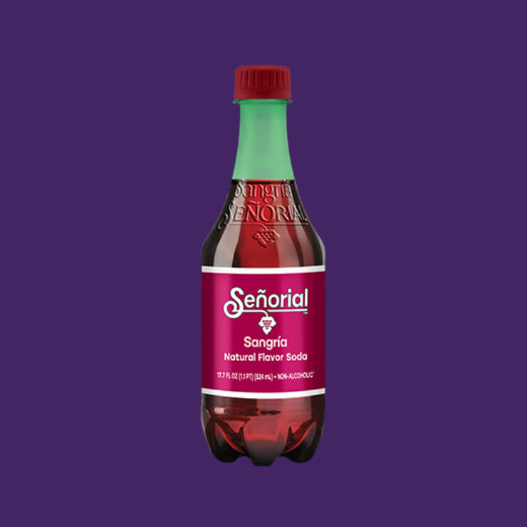 Single bottle of Sangría Señorial natural flavor soda centered on a solid purple background, showcasing its signature burgundy label and green cap.