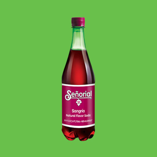 Bottle of Sangría Señorial natural flavor soda centered on a bright green background, showcasing its deep red color and classic label.