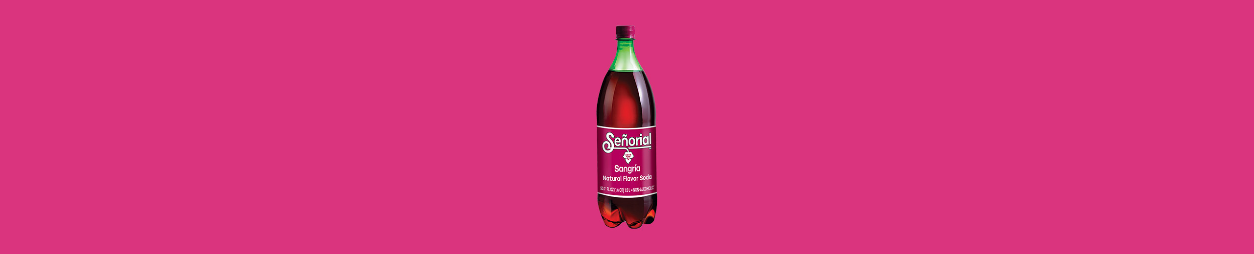 Bottle of Sangría Señorial natural flavor soda displayed at the center of a bright pink background, showcasing its deep red color and iconic label.