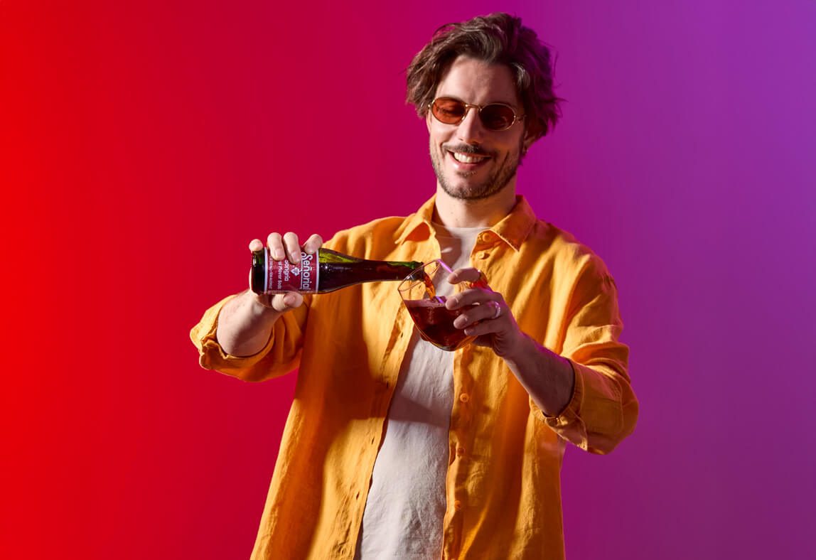 Man pouring Sangria Senorial into a glass, highlighting effortless enjoyment and a vibrant non-alcoholic refreshment.